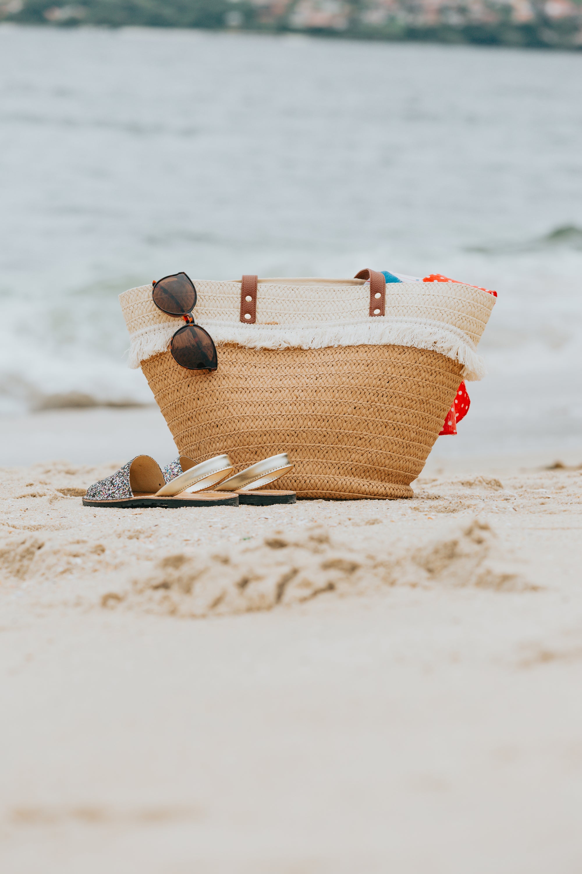 wicker-beach-bag-and-sandals-on-a-white-sandy-beach-Rockport Candle Company